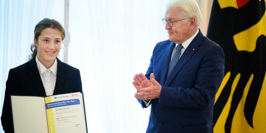 Teilnehmerin der Schüler Uni erhält eine Auszeichnung. Eine junge Teilnehmerin der Schüler Uni erhält eine Auszeichzung vom Bundespräsidenten.