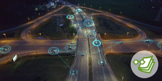Shot of a street at night from above. There are cars connected with light blue lines and circles.