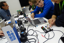 Schülerinnen und Schüler arbeiten im Rahmen eines Projektes am PC und konfigurieren eine Platine.
