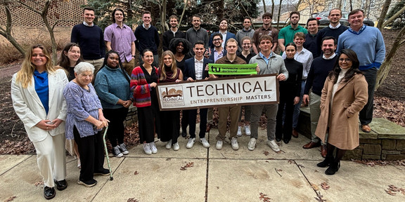 All participants of the Technical Entrepreneurship Week can be seen in a group photo. Some students are holding a banner with the inscription "Technical Entrepreneurship masters". Another student is holding a green scarf with the inscription "Technische Universität Dortmund". 