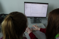 Zwei Teilnehmerinnen entwickeln am PC einen Quellcode.