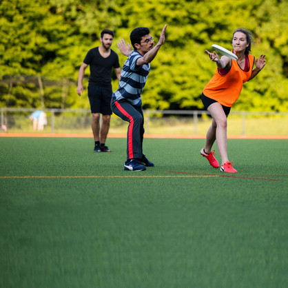Group of Ultimate Frisbee players, a woman just before throwing the frisbee 