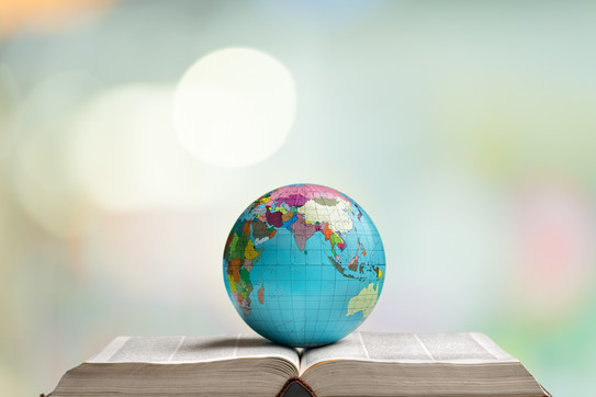 A globe lies on an open thick book.