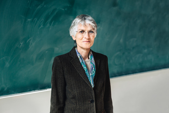 Portrait picture of Dr. Johanna Weber in front of a school blackboard.