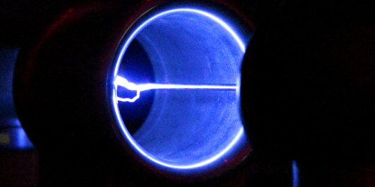 Eine Röhre wird durch einen Strahl blau durchleuchtet