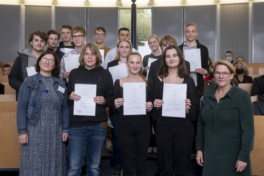 Gruppenfoto Eröffnung Wintersemester 2022/23 Gruppenfoto von den Teilnehmer*innen der SchülerUni im Sommersemester 2022, die ihre Zertifikate in den Händen halten, sowie der Prorektorin Studium Prof. Wiebke Möhring und der Projektleiterin Dr. Irene Szymanski.