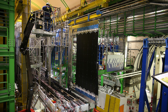 A laboratory with numerous cables, scaffolds and a lifting bridge inside a particle accelerator.