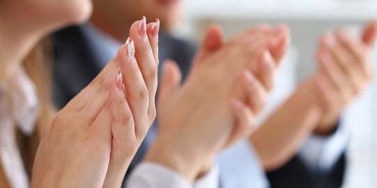 Close up of three pairs of hands clapping into each other