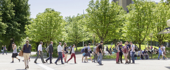 Studentinnen und Studenten laufen über den Campus