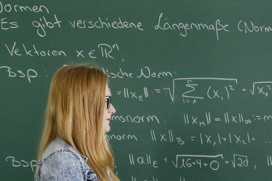 Two students standing in front of a blackboard