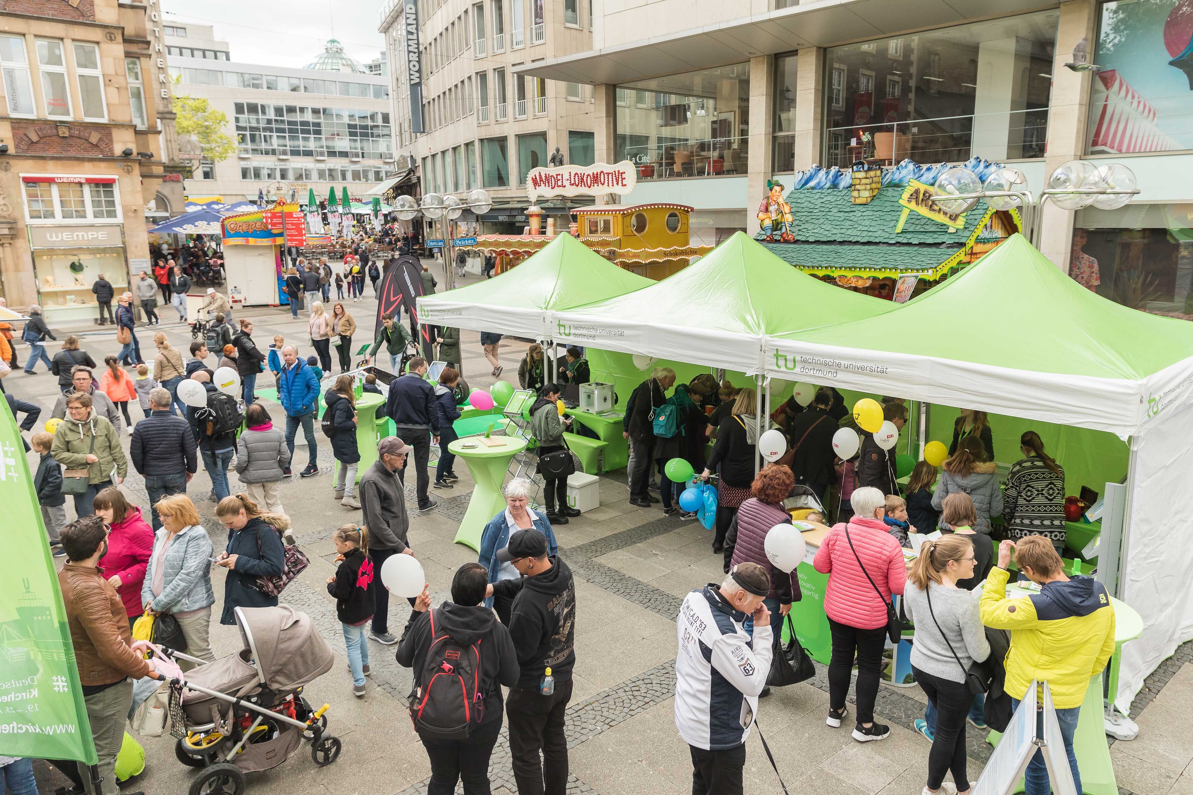 Dortbunt Viele Menschen stehen an und um den TU-Stand in der Innenstadt.