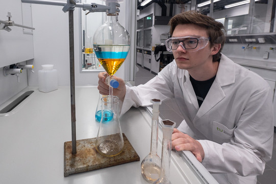 Student führt Experiment mit einem Spitzkolben durch