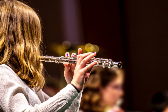 Seitenansicht einer Person, die eine Querflöte spielt.