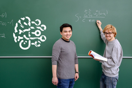 Two people are standing in front of a blackboard with math problems, there is an AI icon on the left of the blackboard
