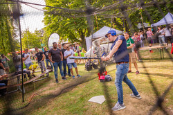 Ein Mann spielt Baseball umgeben von einem Netz