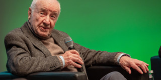 Armin Mueller-Stahl Armin-Mueller-Stahl in einem Sessel vor grünem Hintergrund