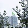 In the foreground snow-covered branches, in the background the Mathetower with green TU logo on the roof.