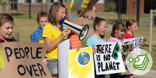 Sieben Kinder demonstrieren mit Plakaten und Megafon für die Umwelt und Nachhaltigkeit.