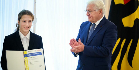 Eine junge Teilnehmerin der Schüler Uni erhält eine Auszeichzung vom Bundespräsidenten.