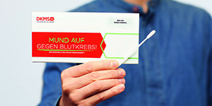 DKMS Eine Person hält ein Registrierungsset der DKMS