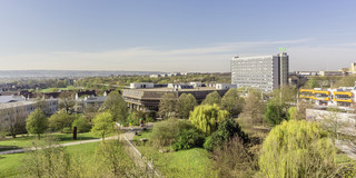 Ein Panorama-Blick des TU-Dortmund Geländes, mittig ist die Universitätsbibliothek zu sehen. Rechts daneben der Mathetower und die Hauptmensa.