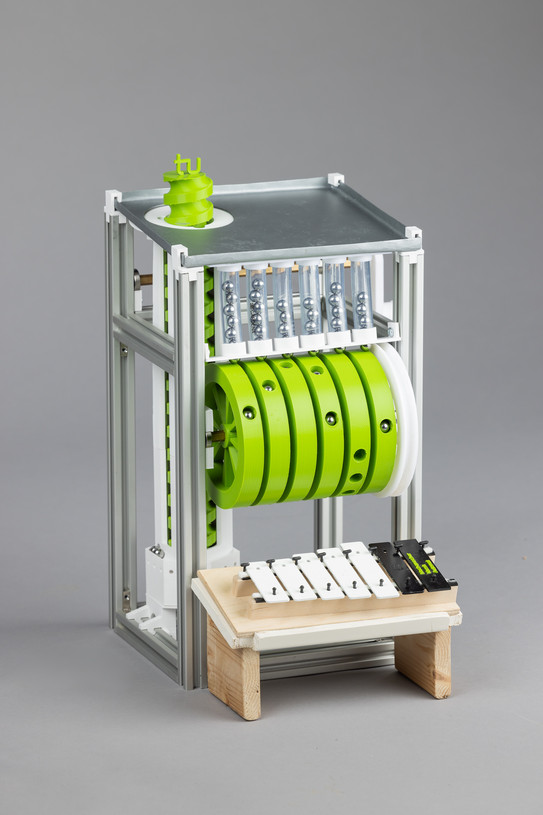 Ein Foto von einem Automat mit grünen Rädern und Kugelaufzug