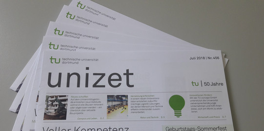 Mehrere Exemplare einer Ausgabe der unizet-Zeitung liegen aufgefächert auf einem Tisch