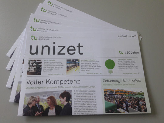 Mehrere Exemplare einer Ausgabe der unizet-Zeitung liegen aufgefächert auf einem Tisch