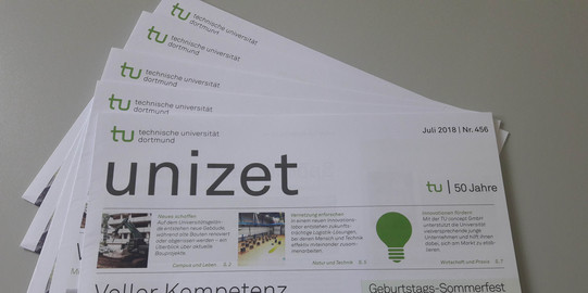 unizet Mehrere Exemplare einer Ausgabe der unizet-Zeitung liegen aufgefächert auf einem Tisch