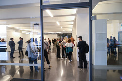 Das Foto gibt einen Überblick über die Ausstellung. Es sind Besucher*innen zu sehen, die sich die Ausstellung ansehen.