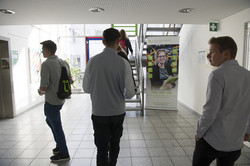 Fünf Personen im Foyer eines Gebäudes.