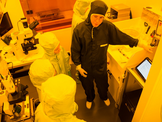 Herstellung eines Mikrochips Schüler*innen in Schutzanzügen in einem Labor.