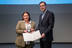 Two people hold up a certificate.