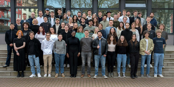 Ein Gruppenbild von rund 60 Studierenden und ihren Dozent*innen draußen auf einer Treppe.