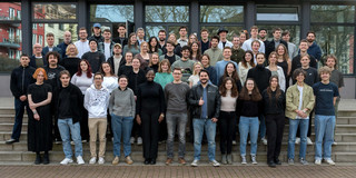 Ein Gruppenbild von rund 60 Studierenden und ihren Dozent*innen draußen auf einer Treppe.