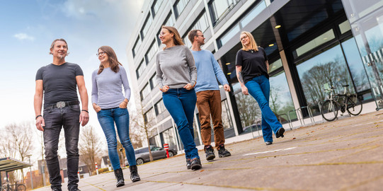Group of employees walking along a modern building.