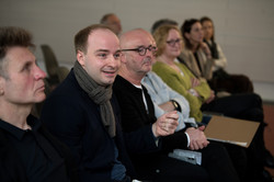 Several people sit next to each other and attend an event.