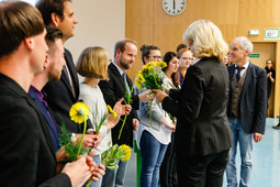 Absolventen/-innen der Absolventenfeier Lehramt bekommen mit Ihrer Urkunde Blumen überreicht