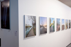 Eine weiße Wand, auf der sieben Bilder angebracht sind