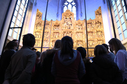 Kinder zu Besuch in der St. Petri Kirche bewundern den goldenen Altar 