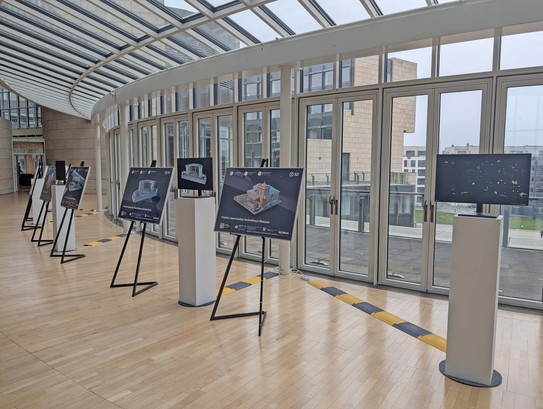 Foto: Eine Ausstellung im Landtag NRW. Das Foto zeigt Aufsteller mit grafischen Darstellungen von Bauwerken. Im Hintergrund ist eine Fensterfront.
