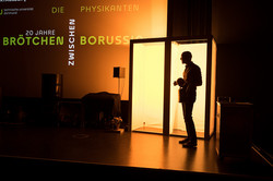 Die Silhouette eines Mannes vor zwei beleuchteten Kammern