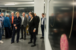 Eine Gruppe Menschen bewundert die Bilder in einer Ausstellung.