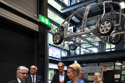 Prof. A. Erman Tekkaya, Prof. Manfred Bayer, Albrecht Ehlers, Prof. Gerhard Schembecker, Katrin Linssen und Ina Brandes stehen in der Experementierthalle. An der Decke hängt das Gerüst eines Autos.