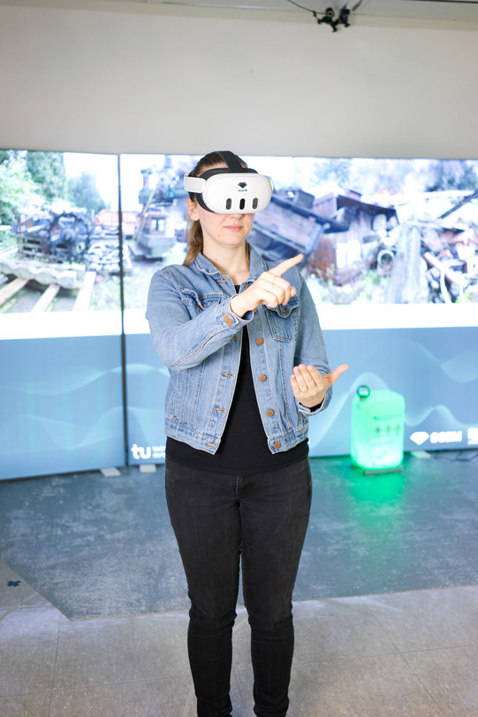 Foto: Eine Person trägt eine VR-Brille und interagiert mit virtuellen Elementen in einer Laborumgebung der TU Dortmund.