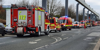 Zahlreiche Feuerwehrwagen auf einer Straße.