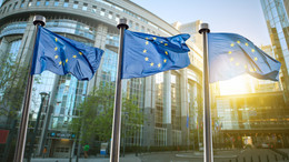 3 EU flags flying in front of the EU Parliament in Brussels.