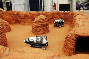Kleine Roboter fahren auf einem Modell der Marsmission.