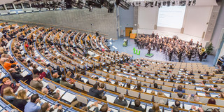 Blick von hinten über vollbesetzte Stuhlreihen im Audimax