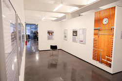 Ein Ausstellungsraum mit einem orangen Poster an der Wand